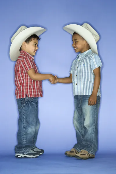 Chicos con sombreros de vaquero estrechando las manos . — Foto de Stock