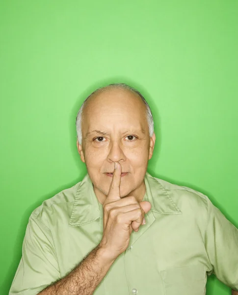 Mann hält Finger an Mund. — Stockfoto
