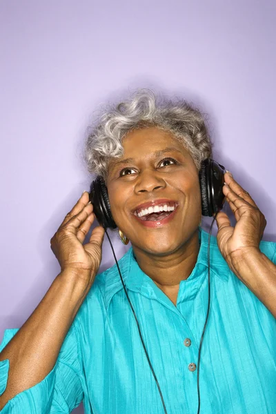 Mujer escuchando auriculares . — Foto de Stock