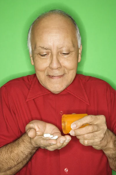 Muž vyprazdňovací pilulku láhev. — Stock fotografie