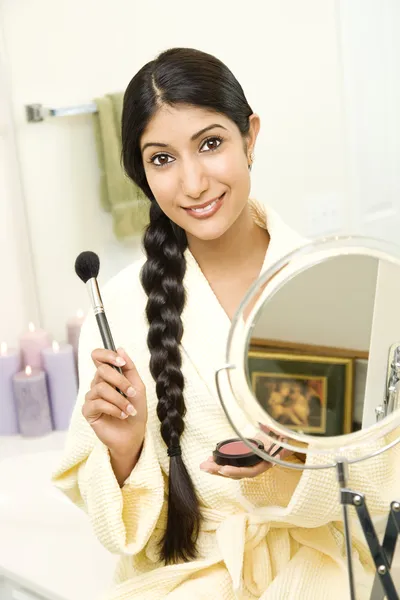 Молодая женщина наносит макияж — стоковое фото