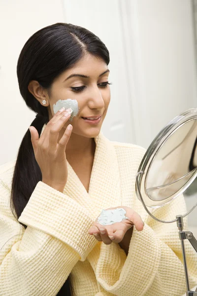 Mujer aplicando tratamiento facial . — Foto de Stock