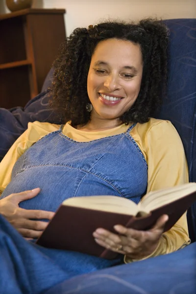 Těhotná žena čtení kniha. — Stock fotografie