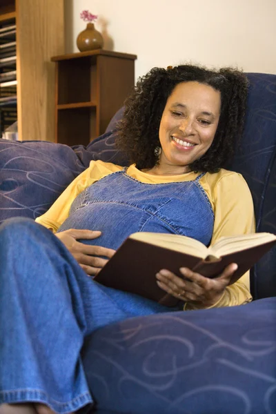 Pregnant smiling woman reading. — Stock Photo, Image