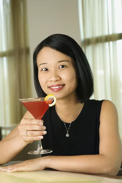 Приваблива молода жінка посміхається з напоєм — стокове фото