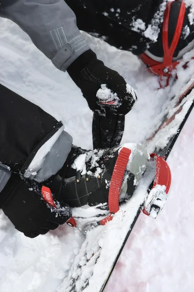 Person schnallt sich auf Snowboard fest. — Stockfoto