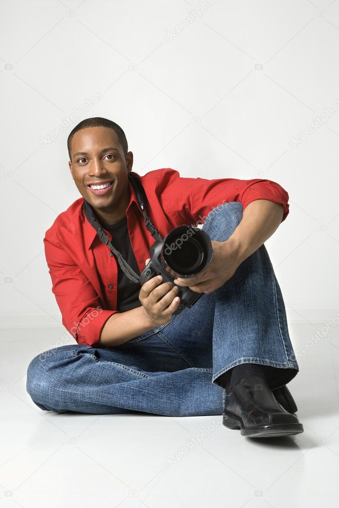 Man with camera smiling.