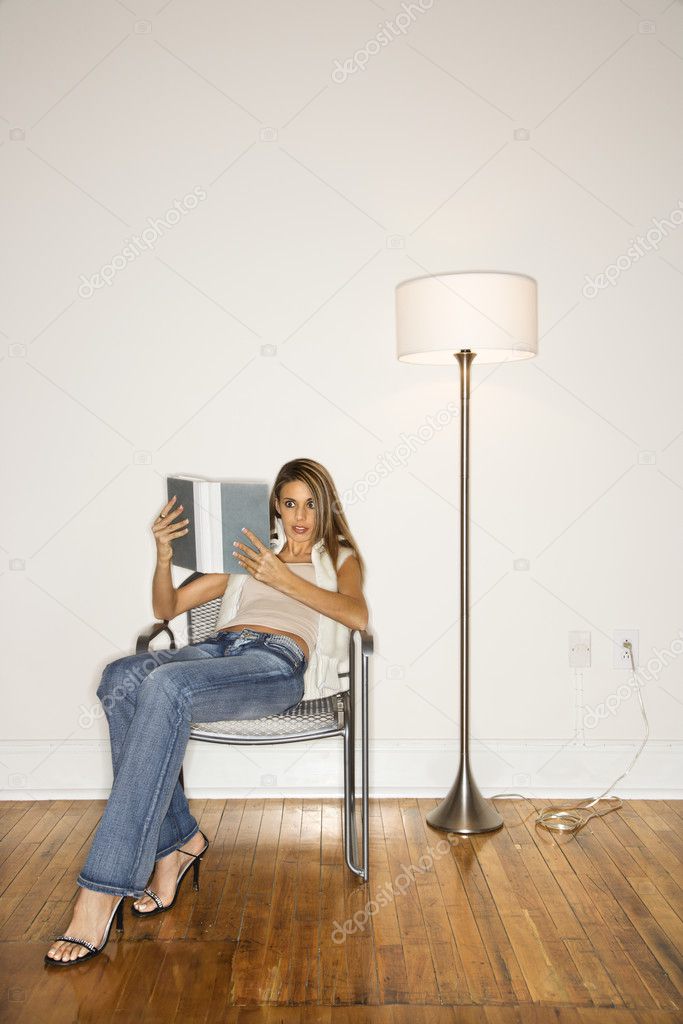 Attractive Young Woman Reading in Chair