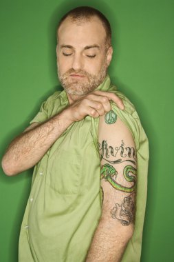 Caucasian man showing tattoo. clipart