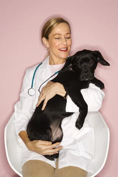 Κτηνίατρος με μαύρο κουτάβι. — Φωτογραφία Αρχείου
