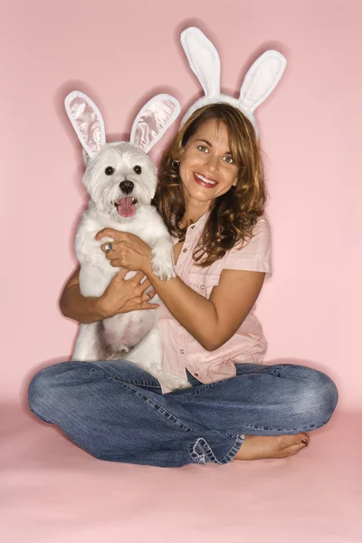 Kobieta i pies sobie uszy królika. — Zdjęcie stockowe