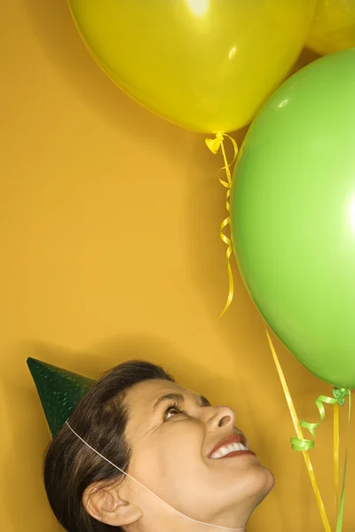 Kvinna i partiet hatt med ballonger. — Stockfoto