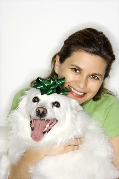 Woman holding white dog. — Stock Photo, Image