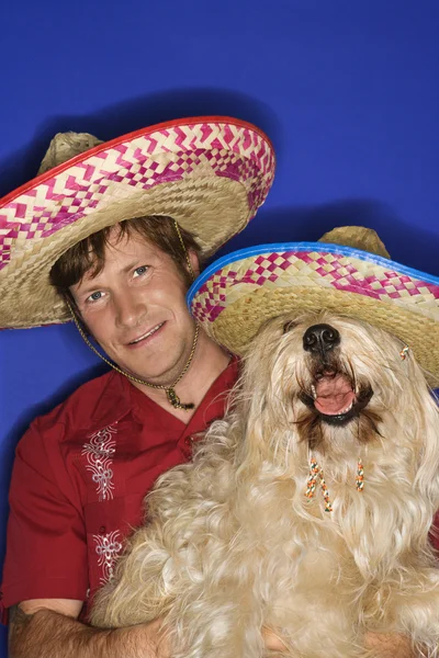 Pes a člověk na sobě sombrera. — Stock fotografie