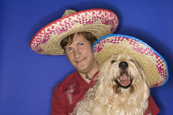 Pes a člověk na sobě sombrera. — Stock fotografie
