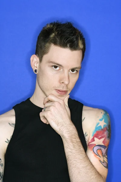 Людина з проколотим вухом та татуюванням . — стокове фото