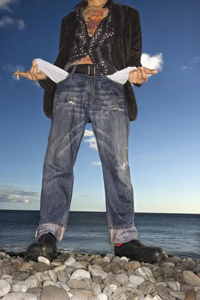 Junger Mann mit leeren Taschen am Strand — Stockfoto