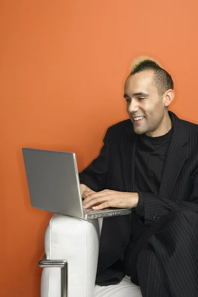 Businessman with mohawk on laptop. — Stock Photo, Image