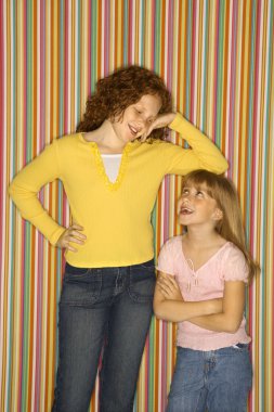 Girl leaning on smaller girl. clipart