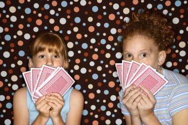 Girls holding playing cards. clipart