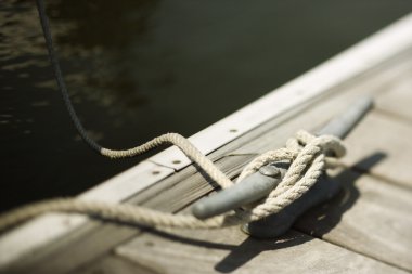 Rope tied to boat dock. clipart