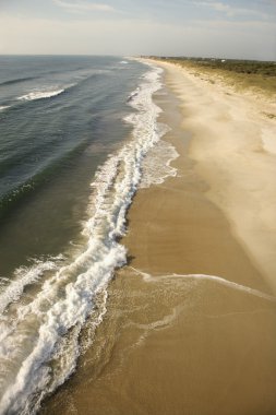 Waves crashing on beach. clipart