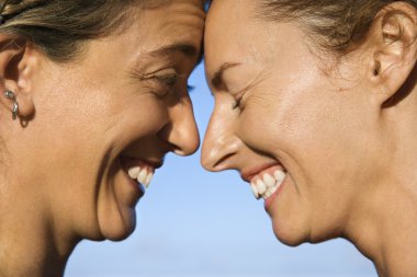 Women head to head smiling. clipart