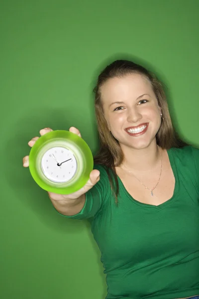 Mujer sosteniendo reloj y sonriendo . — Foto de Stock