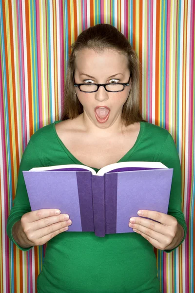 Schockierte Frau liest Buch. — Stockfoto
