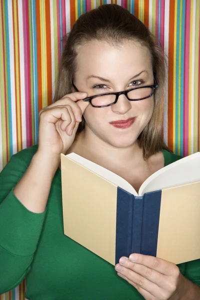 Vrouw met brillen lezen van boek. — Stockfoto