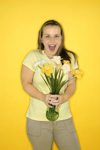 Mutlu bir kadın tutarak çiçekler. — Stok fotoğraf