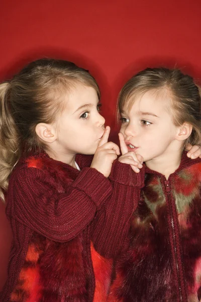 Twins holding fingers to mouths. — Stock Photo, Image