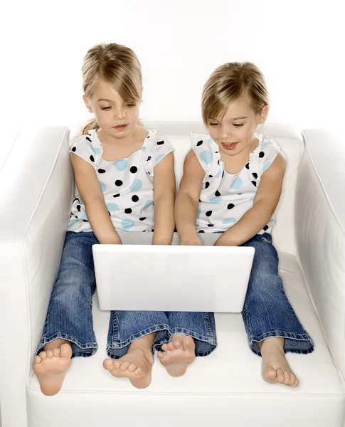 Gêmeos menina com computador portátil . — Fotografia de Stock