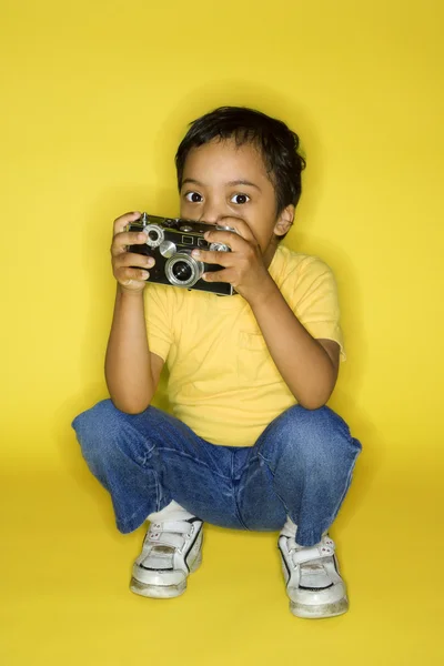 Criança masculina ajoelhada com câmera . — Fotografia de Stock