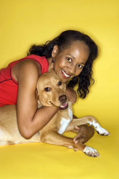 Lächelnde Frau umarmt Hund. — Stockfoto