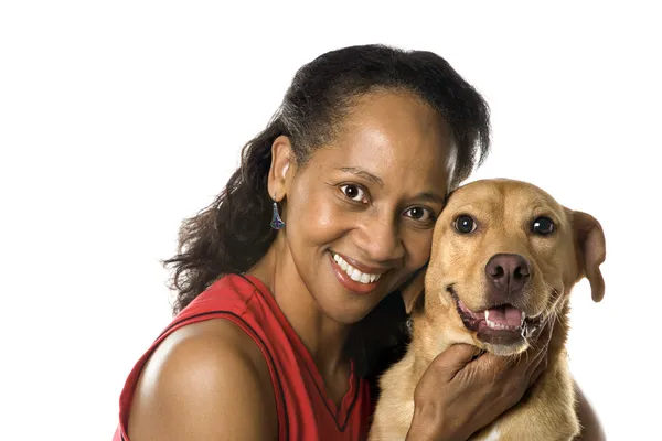 Woman holding dog and smiling. — Stock Photo, Image