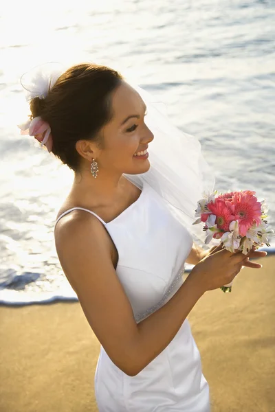 Braut hält Blumenstrauß am Strand. — Stockfoto