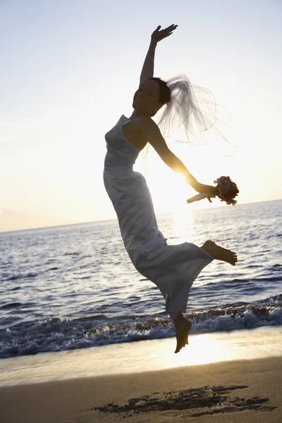 Bride jumping on beach. — Stock Photo, Image