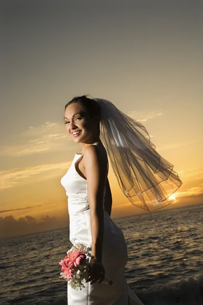 Braut hält Blumenstrauß am Strand. — Stockfoto