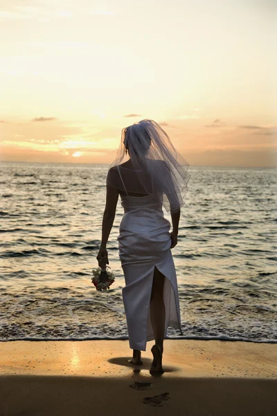 Bride standing on beach. — Stock Photo, Image