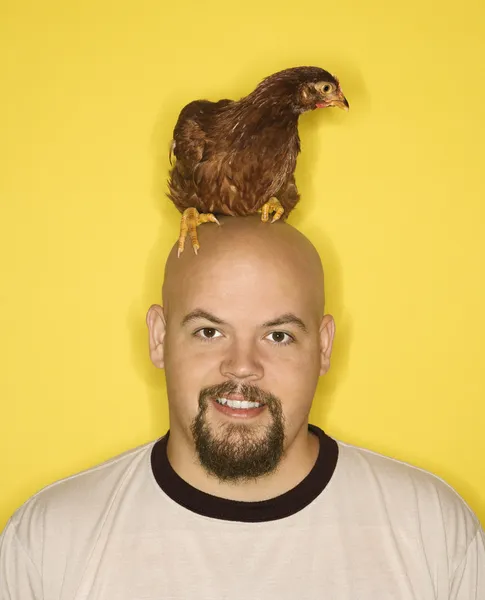 Mann mit Huhn auf dem Kopf. — Stockfoto