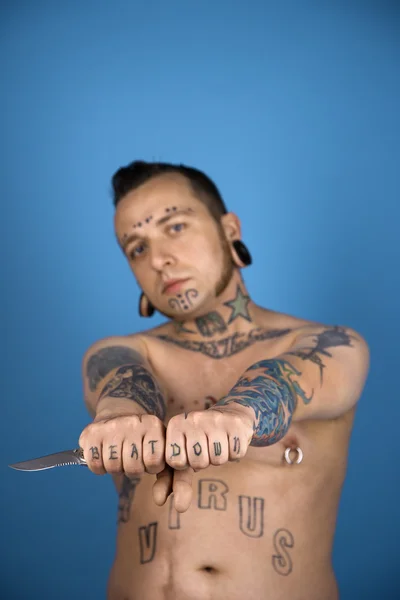 Tatuerade mannen anläggning kniv. — Stockfoto