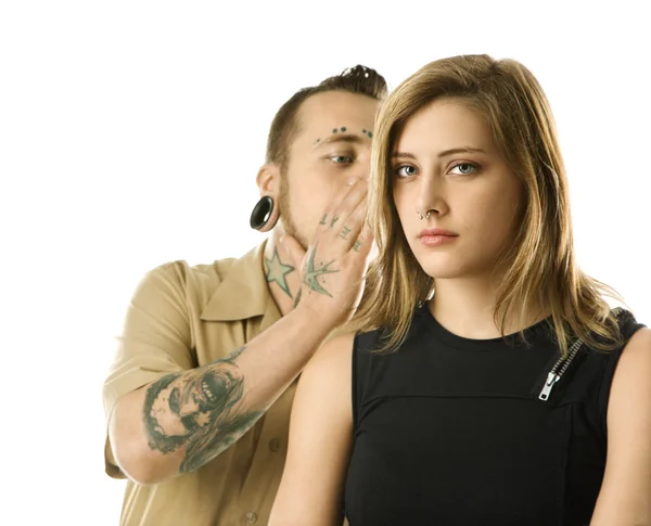 Tattooed man whispering to girl. — Stock Photo, Image