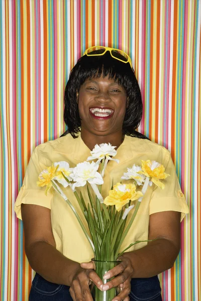 Woman laughing holding flowers. — Stock Photo, Image