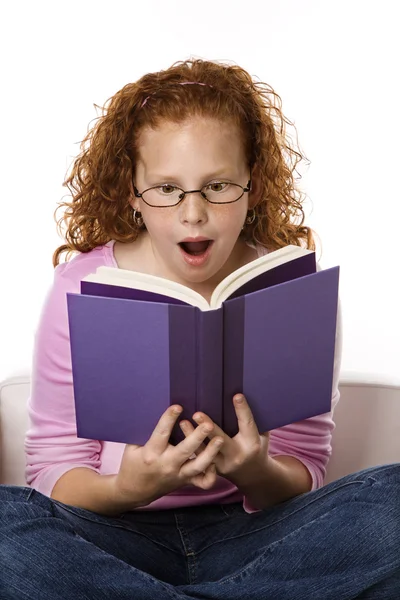 Meisje het lezen van boek naar verbaasd op zoek. — Stockfoto