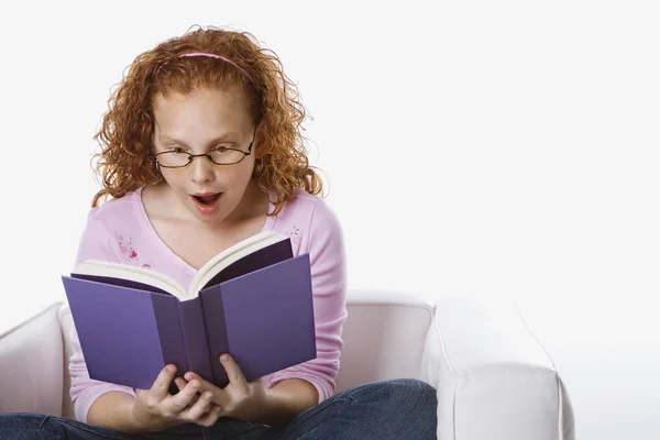 Chica leyendo libro buscando sorprendido . — Foto de Stock