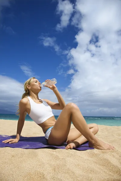 Vonzó fiatal nő iszik a strandon — Stock Fotó