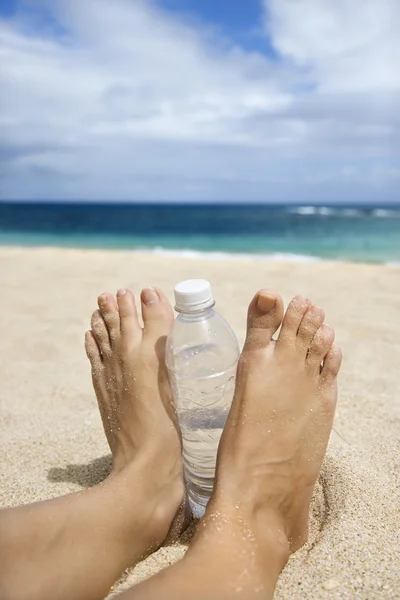Die sandigen Füße der Frau am Strand. — Stockfoto