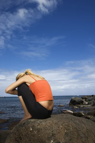 Donna seduta sulla riva rocciosa . — Foto Stock