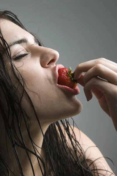 イチゴをかむ女性. — ストック写真